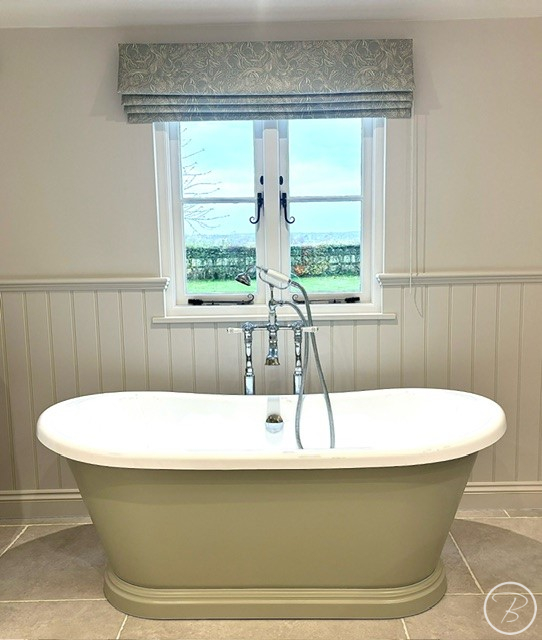 Green painted boat bath under a window