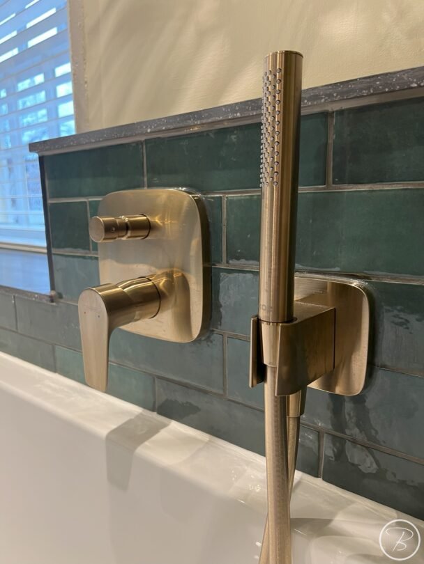 close up of brushed bronze bath taps and handheld shower