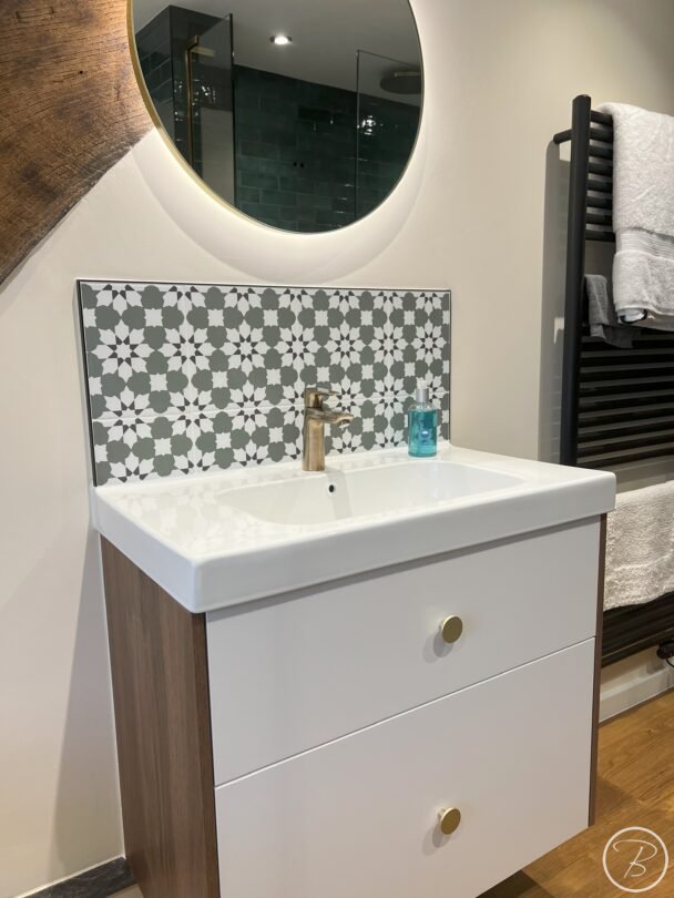 close up view of patterned wall tiles and brushed bronze tap